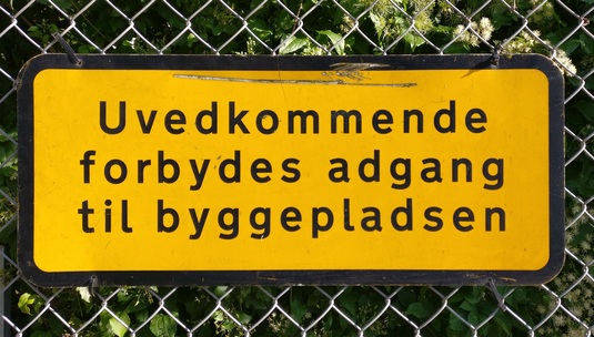 Skylt med texten "Uvedkommende forbydes adgang til byggepladsen".